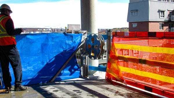 RopeRail deployed with blue and orange netting to provide fall protection and debris containment.